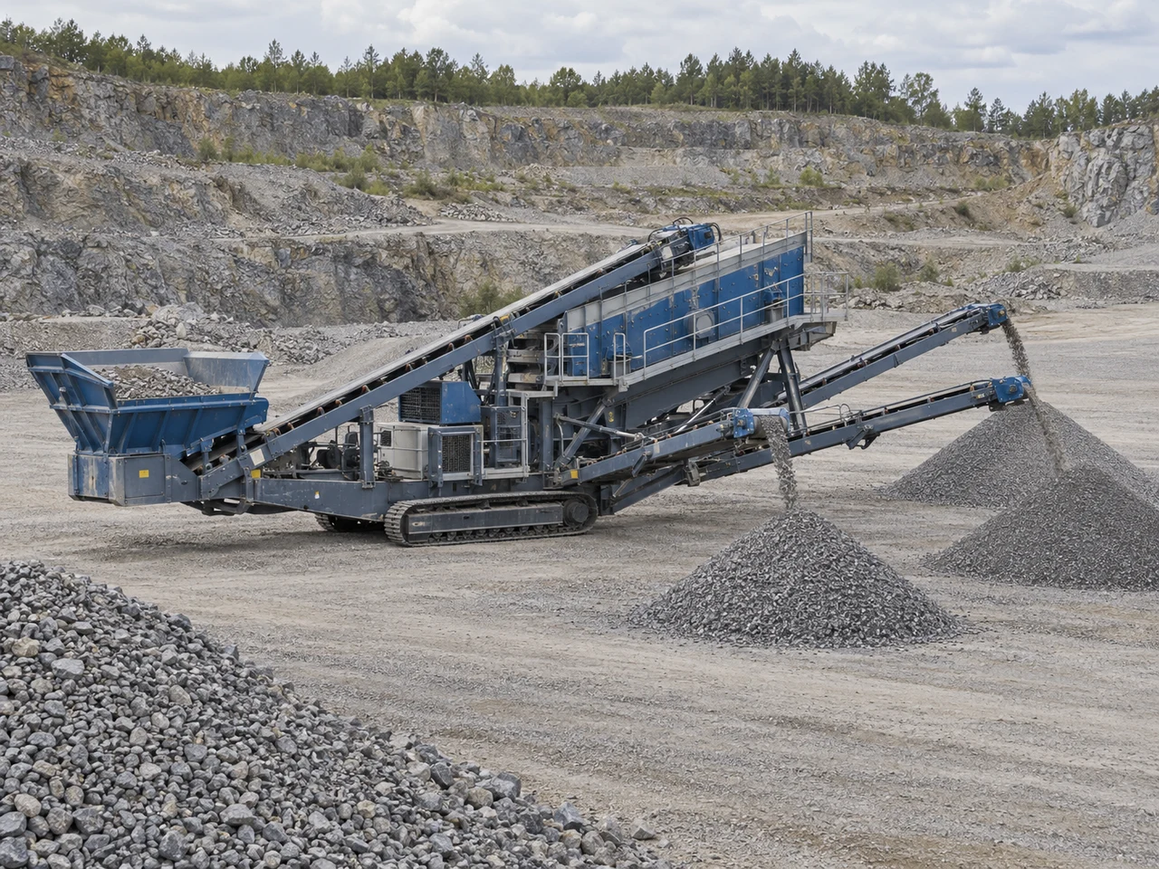 Tracked aggregate screening equipment and separated gravel stockpiles at a quarry